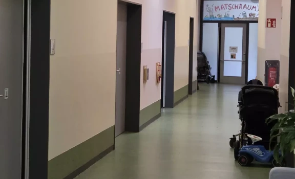 Der Flur der Kita Kunterbunt hat leere Wände, links und rechts von den grauen Türen.