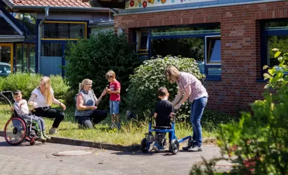 Kinder und ihre Betreuer halten sich vor ihrer Kita auf